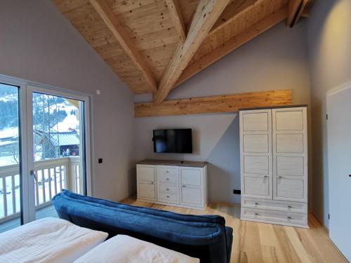 a bedroom with a blue couch in front of a window at Schlossalm Appartement in Bad Hofgastein