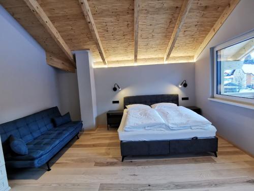 a bedroom with a bed and a couch at Schlossalm Appartement in Bad Hofgastein