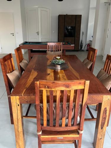 a wooden dining room table with chairs and a pool table at Ferienwohnung Villa Bismarck mit Sauna und Whirlpool in Görlitz