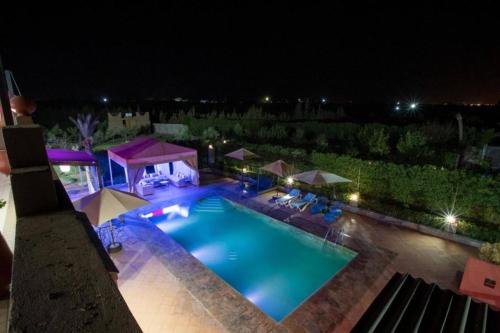 an overhead view of a swimming pool at night at Villa farm host heated pool view Grand Atlas in Tillouna