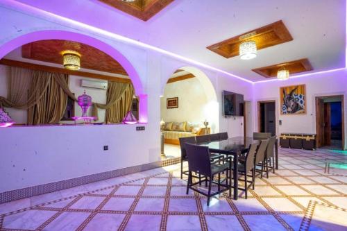 a dining room and living room with a table and chairs at Villa farm host heated pool view Grand Atlas in Tillouna