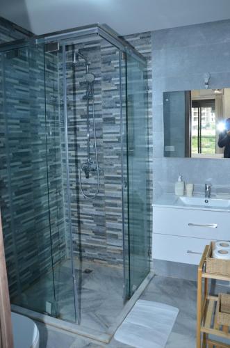 bagno con doccia in vetro, lavandino e servizi igienici di Miramar Prestigia a Ville Nouvelle