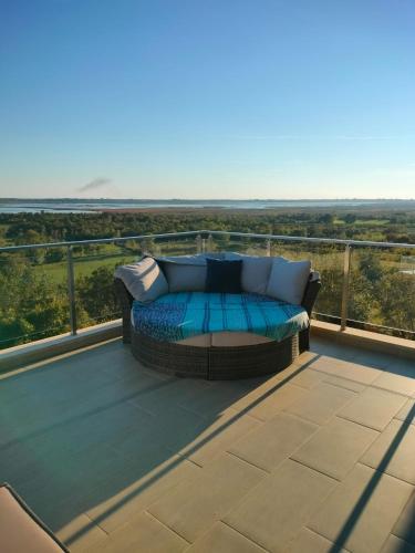 a couch sitting on top of a balcony at Solana's View - Ferienhäuser in ruhiger Lage, mit einer einzigartigen Aussicht, Infinity Pool, Free Parking und Wlan in Ulcinj