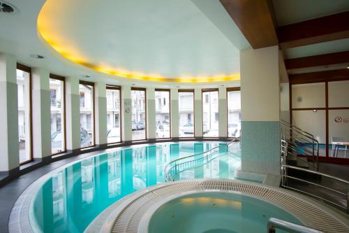 a large swimming pool in a building with a ceiling at Apartamenty Comfort & Spa Stara Polana in Zakopane