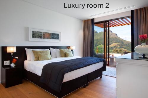 a bedroom with a large bed with a large window at Clouds Estate in Stellenbosch
