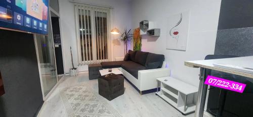 a living room with a couch and a tv at Iva's Apartment in Gostivar