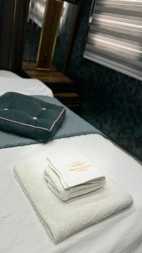 a pile of towels sitting on top of a bed at Hotel Premium in Pristina