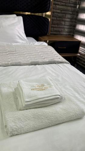 two towels sitting on top of a white bed at Hotel Premium in Pristina
