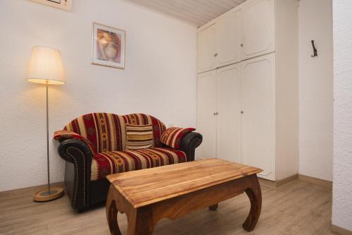 a living room with a chair and a coffee table at Trail Hotel Oberstaufen in Oberstaufen