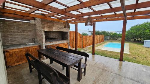 a patio with a wooden table and chairs and a pool at Repunta 2 in Punta Colorada
