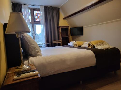 two cats laying on a bed in a hotel room at Hotel Stedswal in Sloten