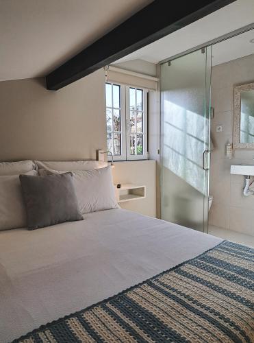 a bedroom with a bed and a glass shower door at Casa Recanto do Teatro in Lamego
