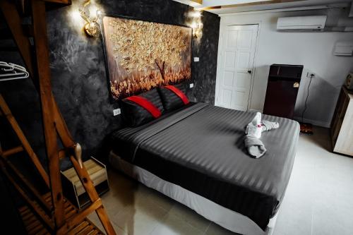 a bedroom with a bed and a painting on the wall at Lemon House apartment in Mae Nam