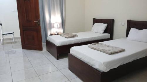 una camera d'albergo con due letti e una porta di Dawhenya Bungalow 2 a Tema