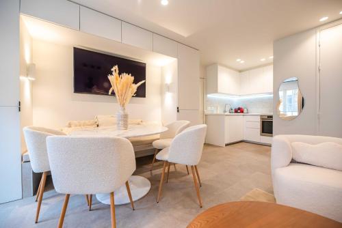 une salle à manger avec une table et des chaises blanches dans l'établissement Elegant apartment - 2BR - 6P - Notre Dame Cathedral, à Paris