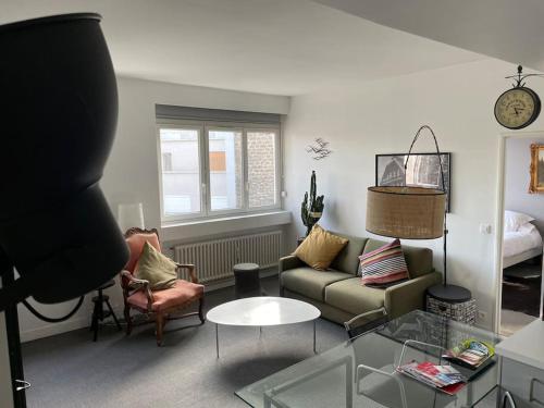 un salon avec un canapé et une table dans l'établissement Paris 16e arrondissement superbe 45 m2 plein sud, à Paris