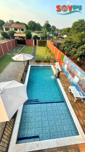 a pool with an umbrella and two chairs and an umbrella at Sublime y moderno alojamiento in Barrio San Isidro (2)