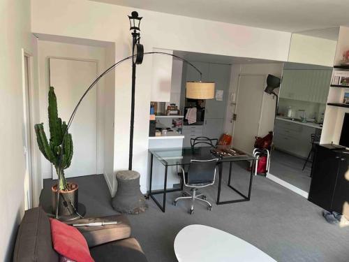 - un salon avec un canapé et une table avec un bureau dans l'établissement Paris 16e arrondissement superbe 45 m2 plein sud, à Paris