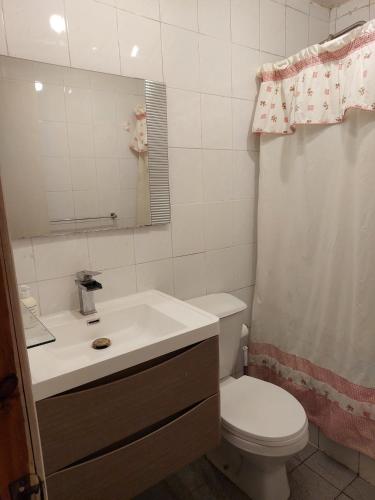 a bathroom with a toilet and a sink and a mirror at Casa cerro Tacna Maitencillo in Maitencillo
