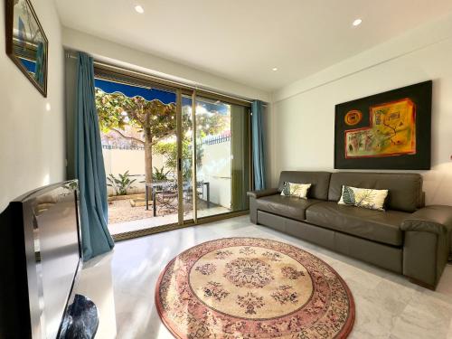 un salon avec un canapé et une grande fenêtre dans l'établissement Le Concorde By SCLS Locations, à Cannes