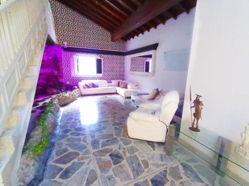 メデジンにあるLuxury Villa at Poblado 6 BDRM Epic Manorの白いソファと壁のあるリビングルーム