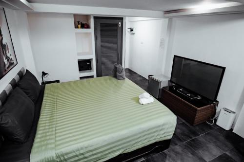 a bedroom with a bed and a flat screen tv at Lemon House apartment in Mae Nam