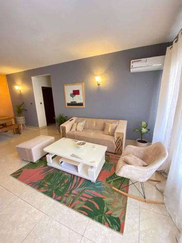 a living room with a couch and a coffee table at Grand Appartement coquet Bastos in Yaoundé