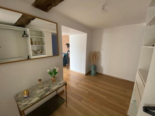 - un salon avec une table et un miroir dans l'établissement Appartement T2 entier, à Corps-Nuds