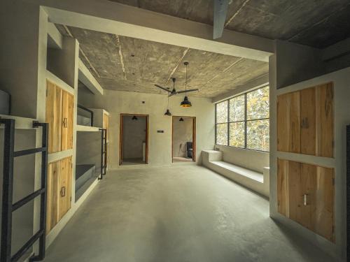 an empty hallway with wooden doors and a window at Vagabond Collective - Coliving & Coworking in Weligama