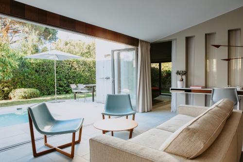 a living room with a couch and chairs and a pool at Sezz Saint-Tropez in Saint-Tropez