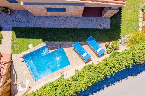 an overhead view of a swimming pool and two blue chairs at Villa Lumière in Costa Paradiso