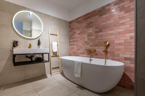 a bathroom with a large tub and a sink at Boutique Hotel Maldegem in Vlissingen