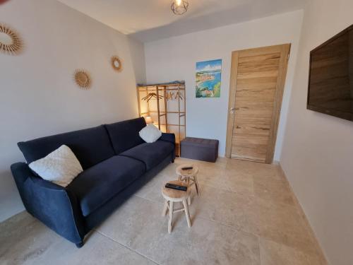 un salon avec un canapé bleu et une table dans l'établissement L'éden des Baronnies, à Mirabel-aux-Baronnies