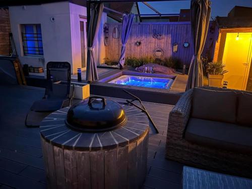 une arrière-cour avec un bain à remous et une table avec une ouverture dans l'établissement Maison de Vacances, à Berck-sur-Mer