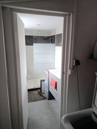 Une porte ouverte s'ouvre sur une cuisine équipée d'un évier. dans l'établissement Maison de Vacances, à Berck-sur-Mer