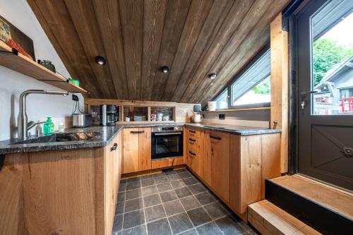 a kitchen with wooden cabinets and a wooden ceiling at Le Grenier sur l'Eau -5 étoiles- Saint-Malo in Saint Malo