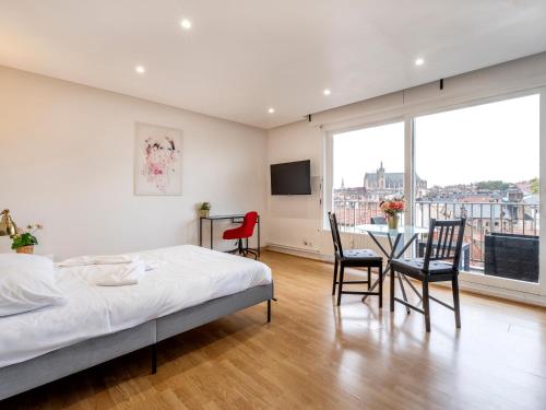 une chambre avec un lit, une table et des chaises dans l'établissement Le Coislin, à Metz