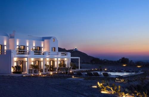 a large white building with a pool at night at Absolute Paradise Santorini in Akrotiri