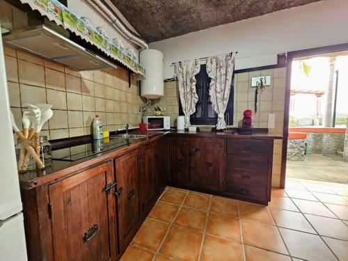 eine Küche mit Holzschränken und einer Arbeitsplatte in der Unterkunft Refugio Jardim Prazeres WiFi BBQ in Prazeres