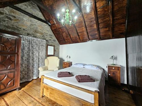 ein Schlafzimmer mit einem Bett und einem Kronleuchter in der Unterkunft Refugio Jardim Prazeres WiFi BBQ in Prazeres