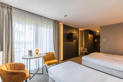 a hotel room with a bed and a table at Parkhotel Horst - Venlo in Horst