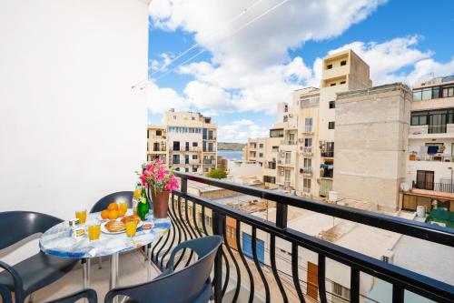 a balcony with a table and chairs with a view at Seashells Apartments with terrace, just off the seafront in Bugibba - by Getawaysmalta in St. Paul's Bay