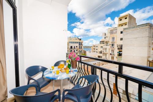 a table and chairs on a balcony with a view at Seashells Apartments with terrace, just off the seafront in Bugibba - by Getawaysmalta in St. Paul's Bay