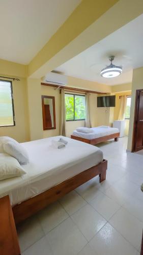 a large bedroom with two beds and a television at Hotel Turístico Marian in Las Terrenas