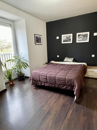 une chambre avec un lit et une grande fenêtre dans l'établissement La GALERIE, à Onet le Château