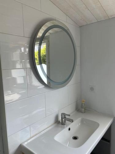 une salle de bain blanche avec un lavabo et un miroir dans l'établissement Maison située à 150m de la plage de la Madeleine, à Noirmoutier-en-l'lle
