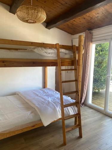 - un lit superposé avec une échelle dans une chambre avec une fenêtre dans l'établissement Maison située à 150m de la plage de la Madeleine, à Noirmoutier-en-l'lle