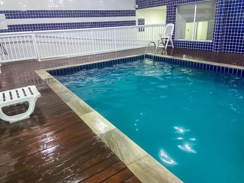 a swimming pool with a chair in the middle at Conforto e Estilo - Enxoval Completo - Bertioga in Bertioga