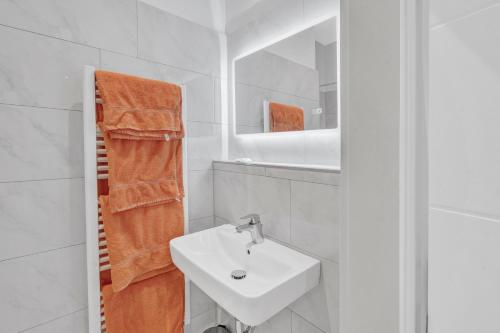 a white bathroom with a sink and a mirror at JAKSE-Apartments - Urban Jungle - top Lage & flexibler Checkin in Bochum