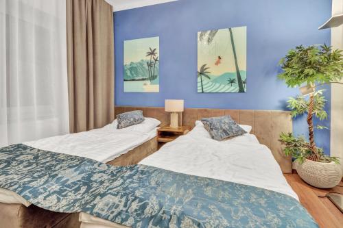 two beds in a room with blue walls at JAKSE-Apartments - Urban Jungle - top Lage & flexibler Checkin in Bochum